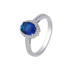 Gros plan détaillé de la bague classique en pierre bleue avec des accents étincelants.