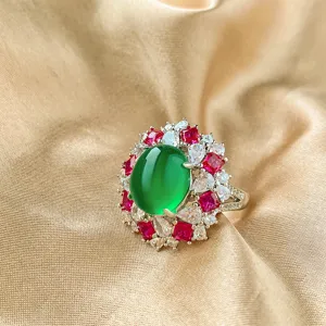 Detailed close-up of a stunning green cabochon gemstone ring with red and clear zirconia stones.