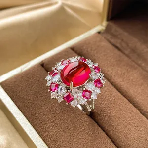 Exquisite pigeon blood red oval corundum cluster ring detail with sparkling cubic zirconia.