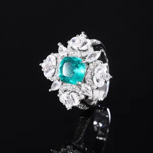 Primer plano detallado de un elegante anillo con piedra preciosa verde y circonitas brillantes.