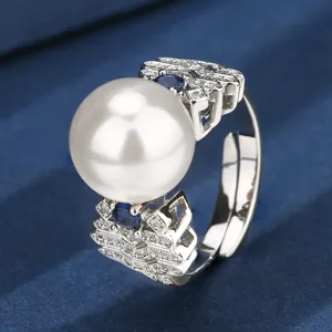Elegant pearl geometric ring with blue stones and shimmering diamonds, luxury jewelry detail shot.