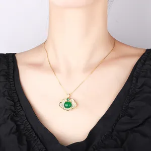 Close-up detail of green gemstone ruyi lock pendant necklace worn on neck, elegant accessory.