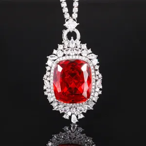 Primo piano di ciondolo in zircone rosso brillante con alone di pavé di zirconi bianchi.