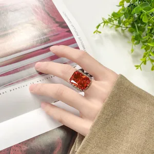 Gros plan d'un bague élégante avec zircone cubique rouge coupe radiant, bijoux fantaisie dorés.