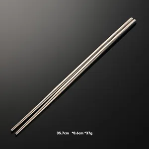 Pure titanium lengthened frying chopsticks detail view, showing metal crystal texture and length.