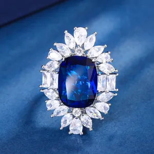 Nahaufnahme des luxuriösen Cluster-Rings mit großem blauen Edelstein und strahlenden Zirkonia.