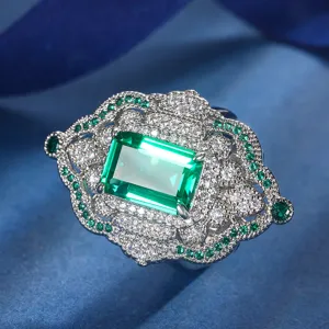 Detailed shot of vintage emerald-cut green gemstone cocktail ring with sparkling cubic zirconia.