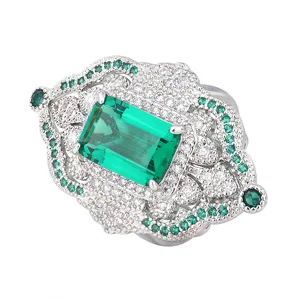 Vintage emerald cut green gemstone ring with sparkling crystal pave in ornate silver tone design.