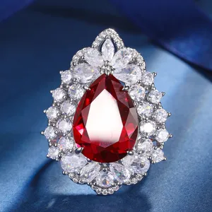 Stunning pear-shaped red gemstone ring detailed close-up, luxury silver-tone cubic zirconia.