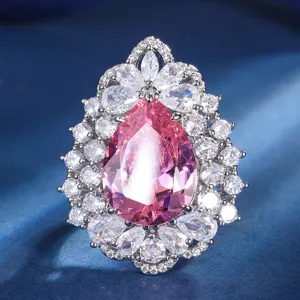 Exquisite pear-shaped pink gemstone ring with dazzling white cubic zirconia halo cluster detail.