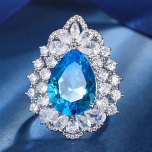Stunning pear-shaped blue gemstone ring detail with sparkling white zircon halo for women.