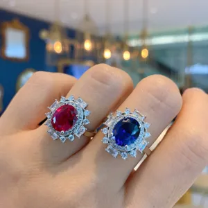 Vintage style oval ruby and sapphire cluster ring set with dazzling cubic zirconia stones.