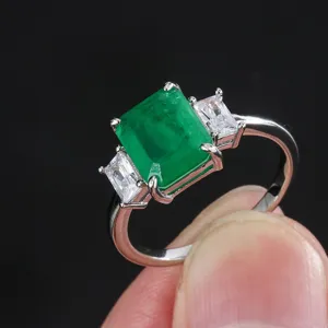 Elegante anello a tre pietre con gemma verde taglio smeraldo e zirconi per donne.