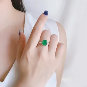 Dettaglio ravvicinato dell'anello con pietra verde smeraldo a tre pietre in argento.