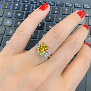 Scatto dettagliato di uno splendido anello a tre pietre con diamante giallo e pietre laterali.