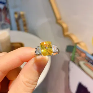 Primo piano dettagliato di un elegante anello luminoso con pietra preziosa gialla.