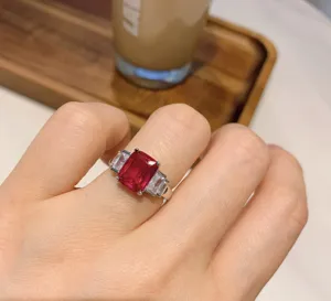 Elegante anello con tre pietre e luminosa gemma rossa rettangolare per donne.