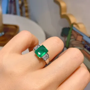 Dettagliato primo piano del bellissimo anello con gemma verde rettangolare indossato.