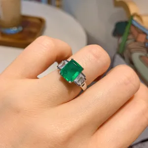 Primo piano dettagliato dell'anello con pietra preziosa verde taglio smeraldo indossato.
