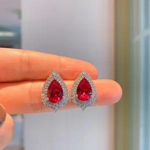 Exquisite pear-shaped red gemstone earrings with sparkling crystal halo, stunning detail shot.
