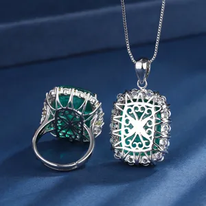 Luxury green gemstone pendant necklace and ring set with sparkling zirconia and intricate details.