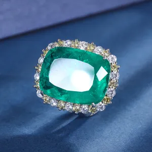 Stunning emerald cut green gemstone ring detail with sparkling crystal halo on blue fabric.