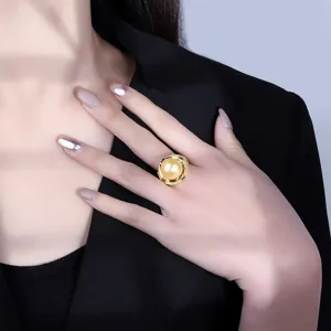 Detailopname van een gouden parelring in vintage stijl met sprankelende strass steentjes.