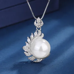 Close-up of elegant silver pearl pendant necklace with sparkling rhinestone leaf design details.