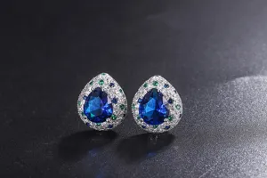 Close-up detail of pear-shaped simulated sapphire cluster earrings with multi-color pavé stones.