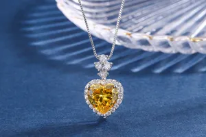 Detaillierte Ansicht einer herzförmigen simulierten gelben Diamant-Halskette mit funkelnden Steinen.