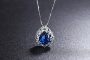 Vintage style pear shaped blue gemstone pendant necklace with colorful zirconia halo.