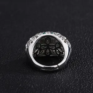 Vue detaillee d'une bague ouverte argentee vintage avec zirconium et trèfle vert.