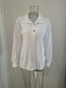 Detailed view of white ribbed long sleeve polo shirt, soft knit fabric texture and button detail.