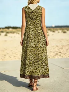 Back view of a casual olive green leopard print hooded maxi dress in a scenic outdoor setting.