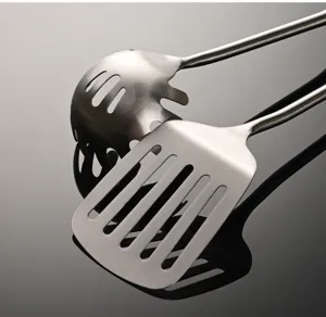 Stainless steel kitchen utensils detail, slotted turner and pasta ladle with long handle.