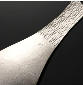 Pure titanium rice spoon handle detail, tree bark texture, metal kitchen tool close up