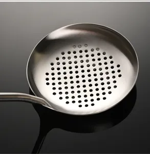 Close-up detail of stainless steel slotted spoon with dense filter holes and hollow handle.