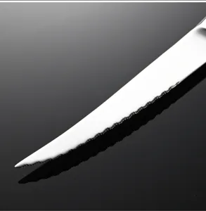 Detalle de cuchillo para carne de acero inoxidable con hoja dentada y acabado brillante.