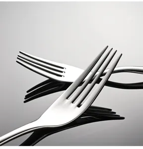 Detalle de tenedor de acero inoxidable, acabado pulido, superficie brillante, mesa elegante.
