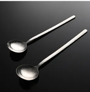 Detalle de cuchara coreana de titanio martillado, exquisita textura de nieve de cristal.