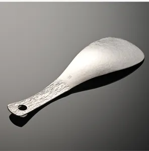 Pure titanium rice spoon with textured handle and hanging hole for home kitchen cooking.