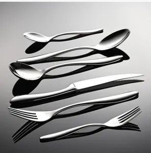 Detalle de juego de cubiertos de acero inoxidable con cuchillo, tenedor y cuchara pulidos.