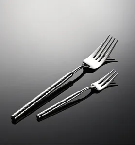 Stainless steel hammered handle fork detail, premium dining tableware presentation.