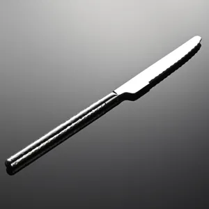 Close up detail of stainless steel steak knife handle with elegant hammered texture.