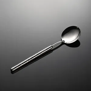 Stainless steel hammered dinner spoon detail view, elegant textured handle, polished surface.