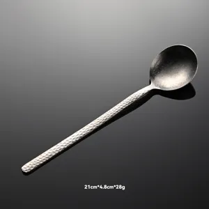 Detalle de cuchara martillada de titanio puro, textura copo de nieve mango largo sopa.