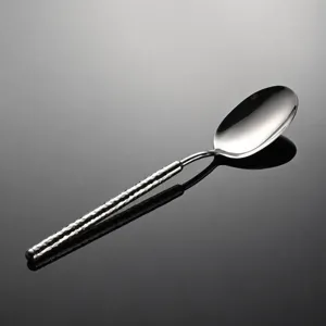 Stainless steel hammered spoon handle detail, mirror polished finish, elegant tableware accent.