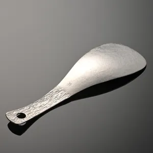 Pure titanium rice paddle with hammered texture and hanging hole for home kitchen use.