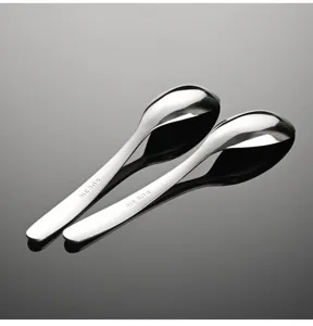 Detailed shot of stainless steel soup spoons with polished mirror finish and engraved handle.
