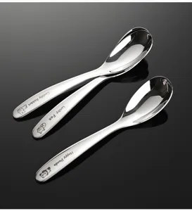 Stainless steel baby spoon handle detail showing cute cartoon animal engravings and polished finish.
